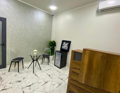 a living room with a table and chairs and a tv at Family Lounge in Matriouene