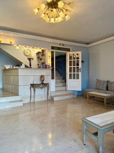 a living room with a couch and a chandelier at Hotel Derveni Georgiadis in Stómion