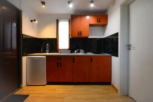 a kitchen with wooden cabinets and a sink and a window at Chatka in Stegienka