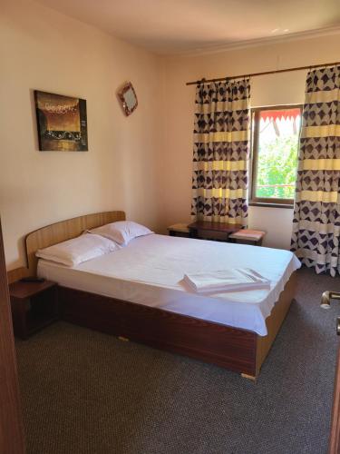 una camera da letto con un grande letto con lenzuola bianche e una finestra di Vila Roxana 2 Mai a 2 Mai