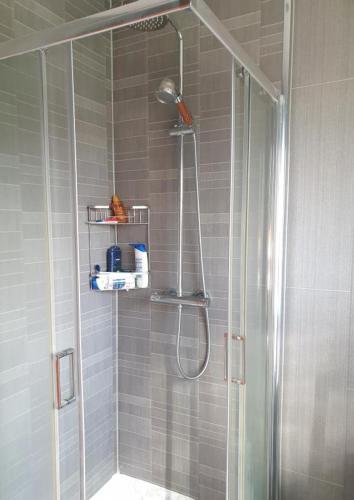 a shower with a glass door in a bathroom at 2 double bedroom house 20mins walk to Durham city centre in Gilesgate