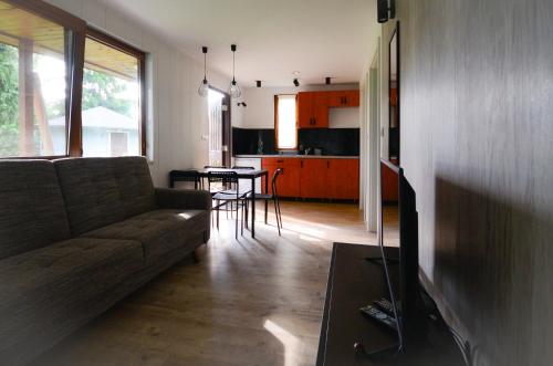 a living room with a couch and a table and a kitchen at Chatka in Stegienka