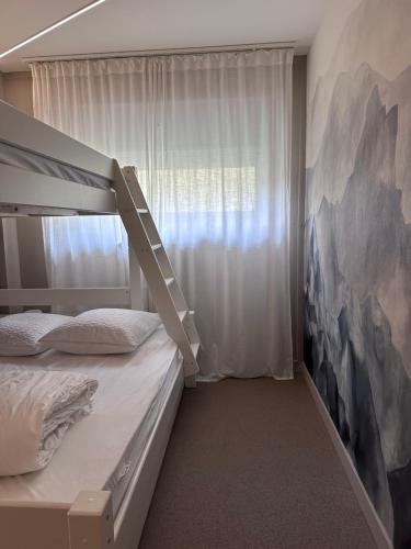 - une chambre avec des lits superposés et un tableau mural dans l'établissement L'Appartement La Mongie, à Bagnères-de-Bigorre