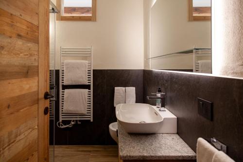 een badkamer met een wastafel en een spiegel bij Méijon Salluard RTA in Courmayeur