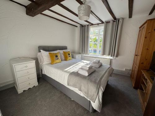a bedroom with a bed with yellow pillows and a window at Vesna Affordable comfort in Newtown