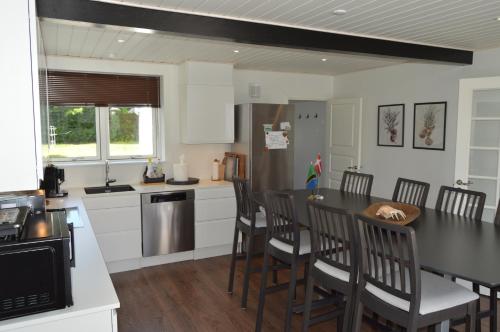 a kitchen with a table and chairs and a refrigerator at Serengeti & Stayover in Svebølle
