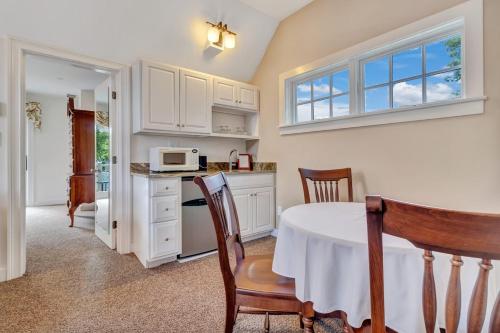 a kitchen with a table and chairs and a microwave at The Winstead Inn in Harwich