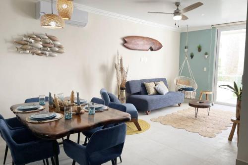 a living room with a wooden table and blue chairs at Nido De Tortuga Akumal With Beach Access And Private Jacuzzi in Akumal
