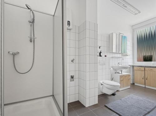 a white bathroom with a shower and a toilet at Zentrale Wohnung für 9 Gäste nahe Schlossplatz in Stuttgart