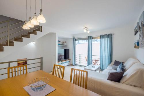 a living room and dining room with a couch and a table at Lightbooking Costa Antigua Fuerteventura in Costa de Antigua