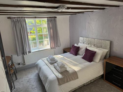 a bedroom with a large white bed with purple pillows at Vesna Affordable comfort in Newtown