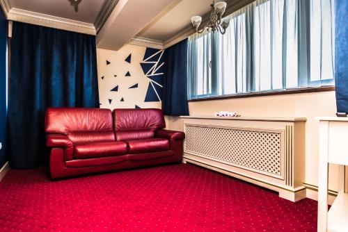 a red chair in a room with a red carpet at Sky Park Home in Iaşi
