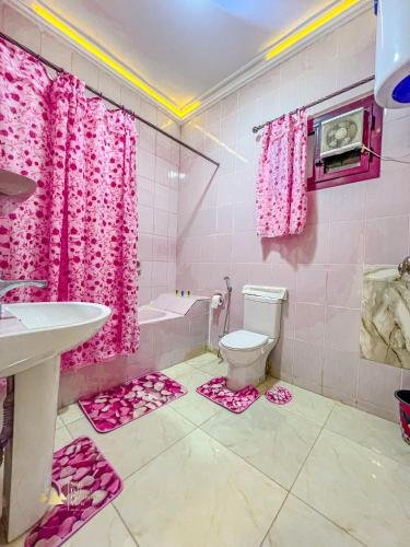 a pink bathroom with a toilet and pink shower curtain at Sidi Hamad Pyramids View King Studio in Cairo