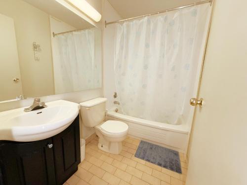 a bathroom with a sink and a toilet and a shower at Idlewood Inn in Toronto