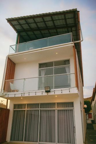 a house with a balcony on top of it at Plateia - Casa de Playa en Zorritos in Bocapán