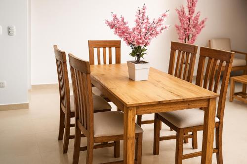 a wooden table with chairs and a potted plant on it at Plateia - Casa de Playa en Zorritos in Bocapán