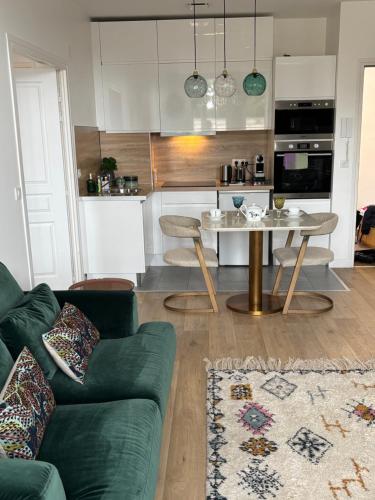 a living room with a green couch and a table at Cocoon Retreat in Chantilly