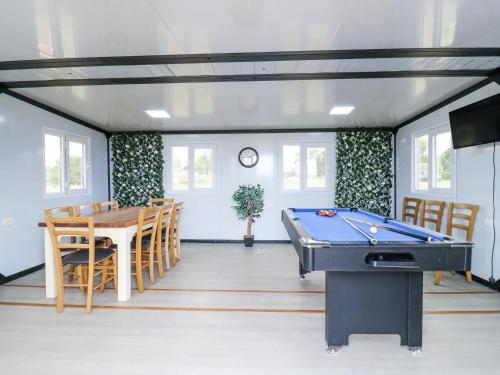 a room with a pool table and a dining room at Luxury Shepherd Hut with Private Hot Tub in Swaffham Bulbeck