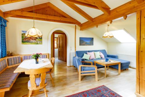 a living room with a blue couch and a table at Landhaus Birgbichler - Apartments mit Bergblick inklusive Sommercard in Ramsau am Dachstein