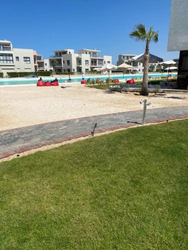 a view of a beach with a palm tree at Lovely penthouse 4- bedroom directly on the lagoon in El Alamein