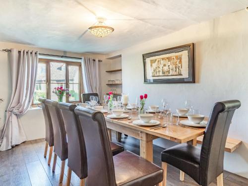 a dining room with a wooden table and chairs at Horseshoes House in Watton