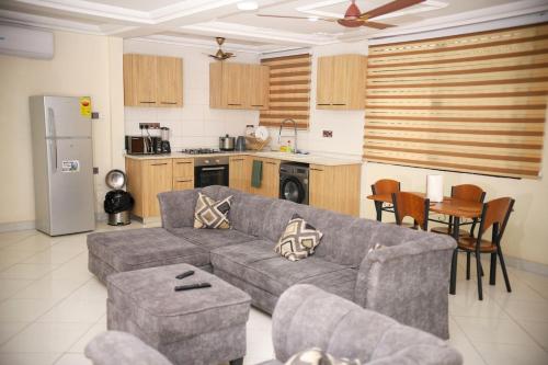a living room with a couch and a kitchen at Stylish Affordable Studio Apartment RealShala Homes- Accra in Ashalebotwe