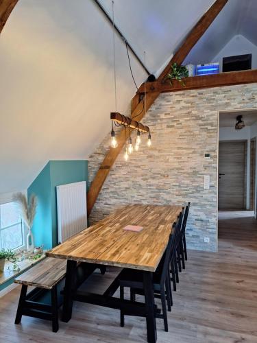 a dining room with a wooden table and chairs at Spring Lodge - La grange aux quatres saisons - Pairi Daiza in Brugelette