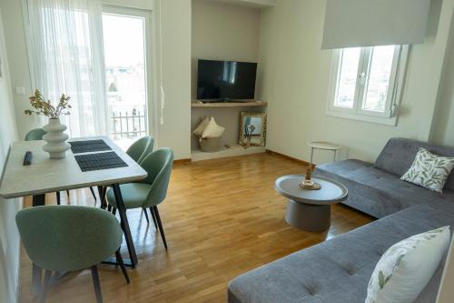 un soggiorno con un divano e un tavolo con un computer portatile di Ethereal Kavala a Kavala