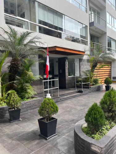 a flag in front of a building with plants at Bello Departmento - Miraflores in Lima