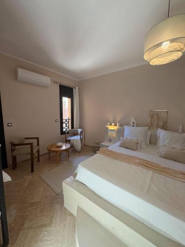 a bedroom with a large white bed in a room at Riad Perles d'Annellia in Marrakech