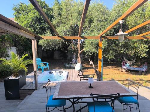 a patio with a table and chairs and a pool at Agréable maison avec jacuzzi in Vinassan
