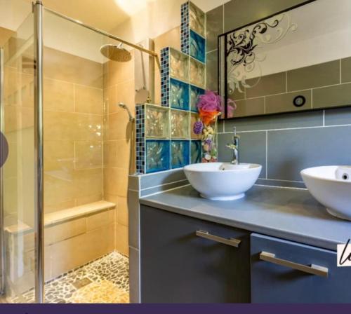 a bathroom with two sinks and a shower at Agréable maison avec jacuzzi in Vinassan
