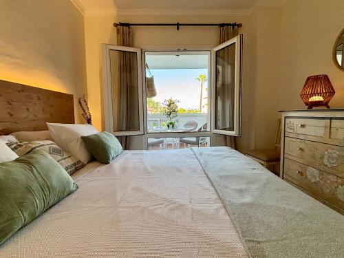 a bedroom with a large bed with a large window at Playa Rocio calm beachfront apartment- 2bdr in Marbella