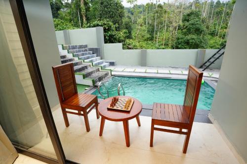 a room with two chairs and a table and a pool at LA VILLA Resort in Vythiri