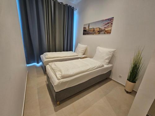 two beds in a room with a window at ApartHotel Rahl 24h Self Check-in in Hamburg