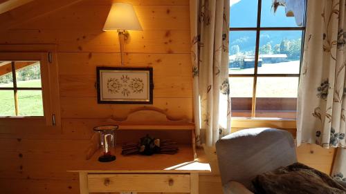a room with a wooden wall with a table and a lamp at Farfalla Penthouse Apartment in Gstaad