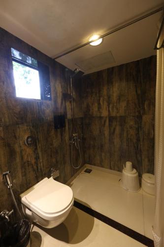 a bathroom with a toilet and a shower at Aayush Resort in Kālundri
