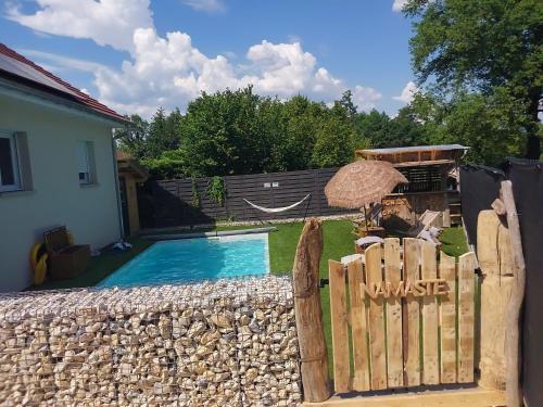 une cour avec une clôture et une piscine dans l'établissement Maison neuve proche station de ski, 10 couchages, tout confort, à Granieu