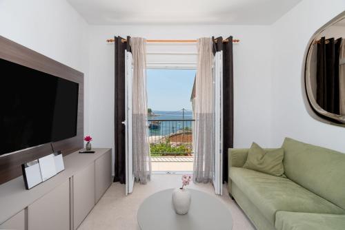 a living room with a green couch and a television at Luxury apartments Lun in Lun