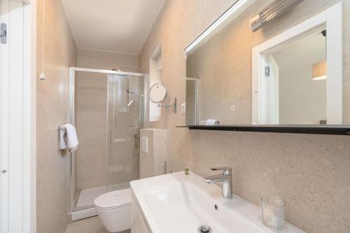 a bathroom with a sink and a shower and a toilet at Luxury apartments Lun in Lun