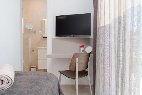 a bedroom with a bed and a chair and a television at Luxury apartments Lun in Lun
