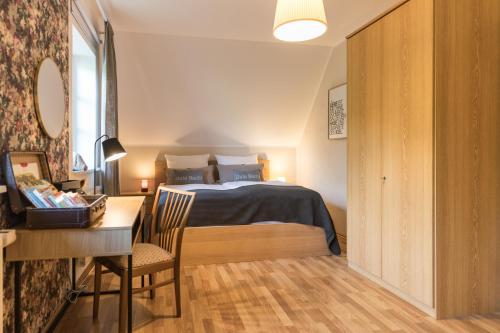 a bedroom with a bed and a desk and a table at Fachwerk-Ferienhaus, Ruhe auf dem Land, Haustiere willkommen, Leihfahrräder, 24-7 check in in Kirchlinteln
