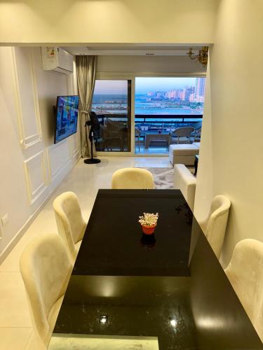 a dining room with a black table and chairs at ALEX HOMES - Gleem Luxury Apartments with Direct Sea View in Alexandria