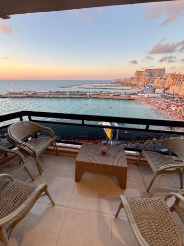 a balcony with chairs and a view of the ocean at ALEX HOMES - Gleem Luxury Apartments with Direct Sea View in Alexandria
