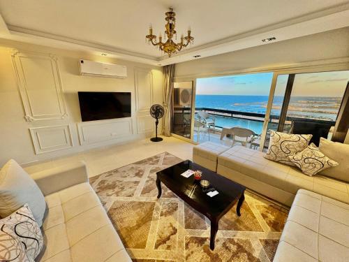 a living room with a couch and a view of the ocean at ALEX HOMES - Gleem Luxury Apartments with Direct Sea View in Alexandria