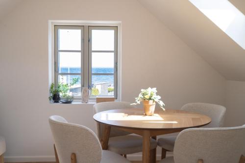 a dining room with a table and chairs and a window at Lille villa med havudsigt og sauna in Espergærde