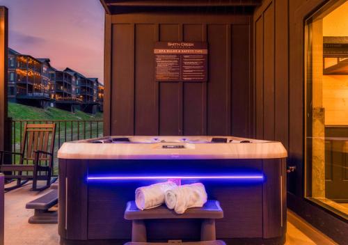 a jacuzzi tub on a deck with two towels at The Wolf's Lantern Highway in Pigeon Forge