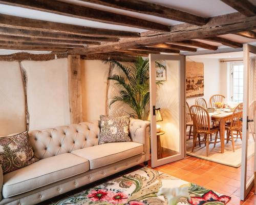 ein Wohnzimmer mit Sofa und Tisch in der Unterkunft Straw Plaiters Cottage in Wendover