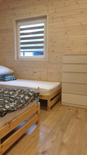 a log cabin with two beds and a window at Błękitna Laguna 600m od morza in Rusinowo