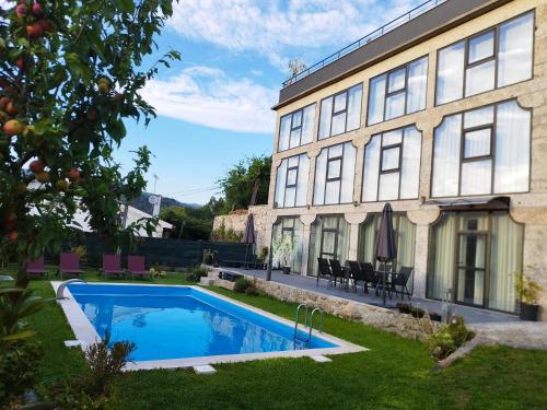 ein Haus mit einem Swimmingpool neben einem Gebäude in der Unterkunft Sequeira Arantes Casa 1 in Terras de Bouro